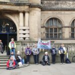 People stood outside Sheffield Town Hall with banners reading Sheffield Climate Vigil