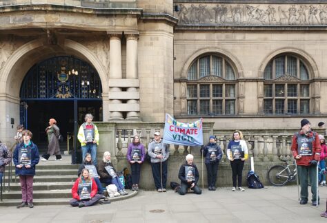 People stood outside Sheffield Town Hall with banners reading Sheffield Climate Vigil