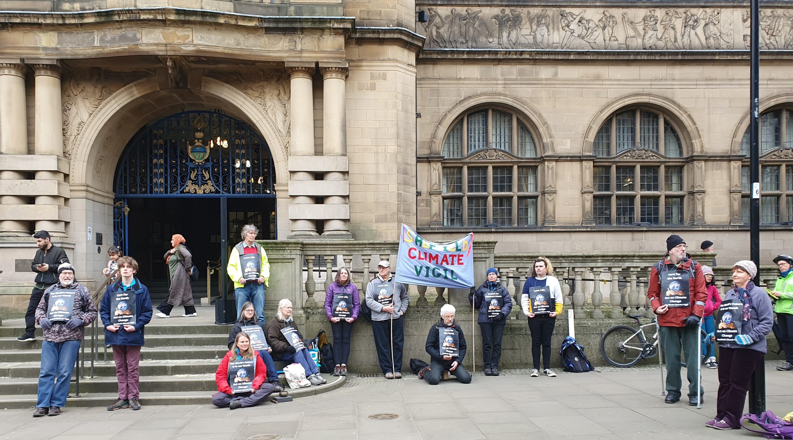 People stood outside Sheffield Town Hall with banners reading Sheffield Climate Vigil