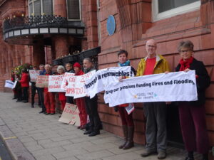 A group of campaigners holding banners outside a conference venue