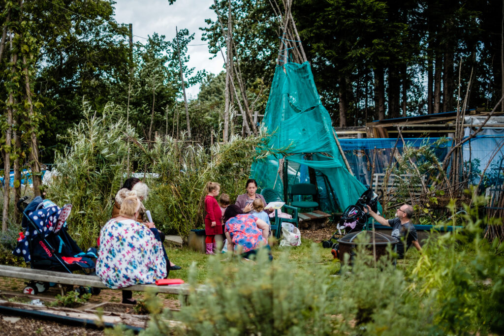 People in an urban farm setting reading to children